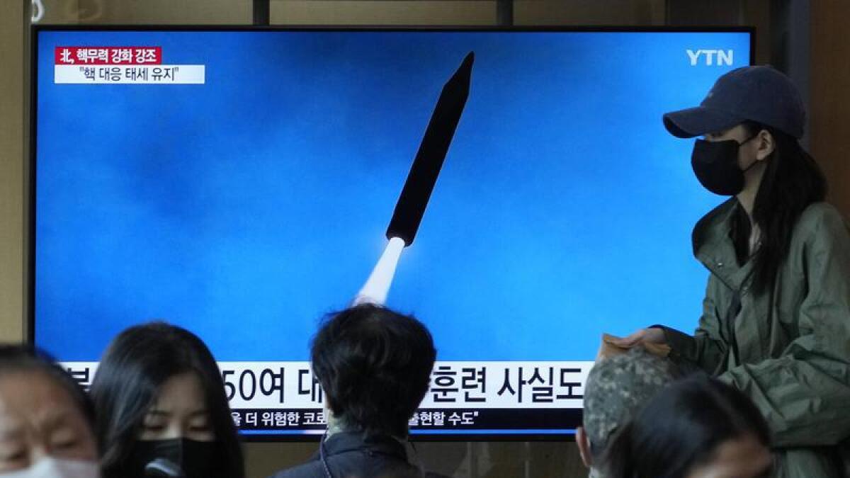 A TV screen shows an image of a North Korean missile launch
