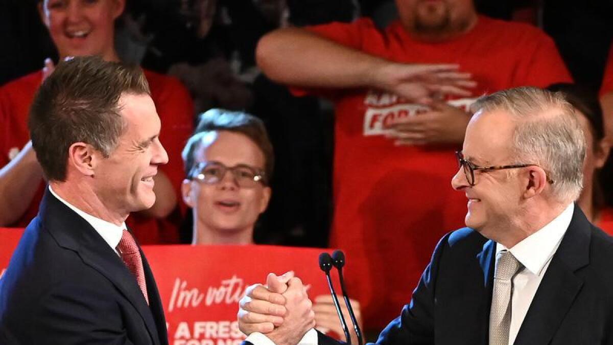 NSW Labor Leader Chris Minns grasps hands with Anthony Albanese.