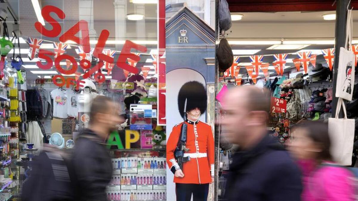 Pedestrians pass a souvenir shop on Oxford Street in London
