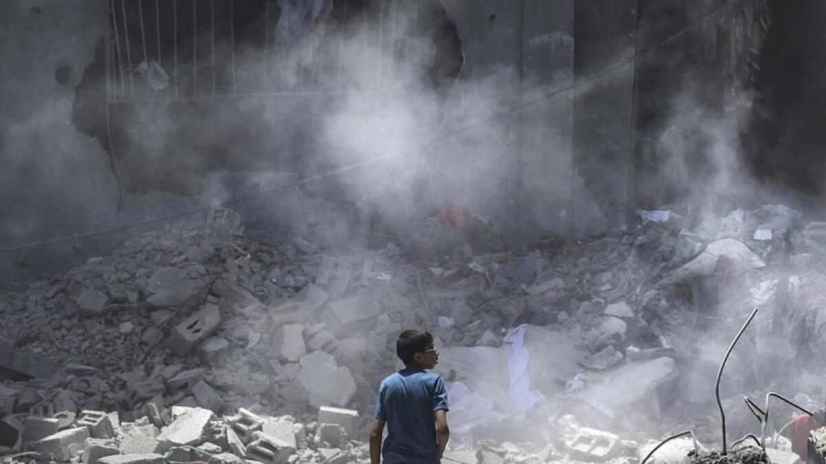 Boy inspects damage following an Israeli air strike