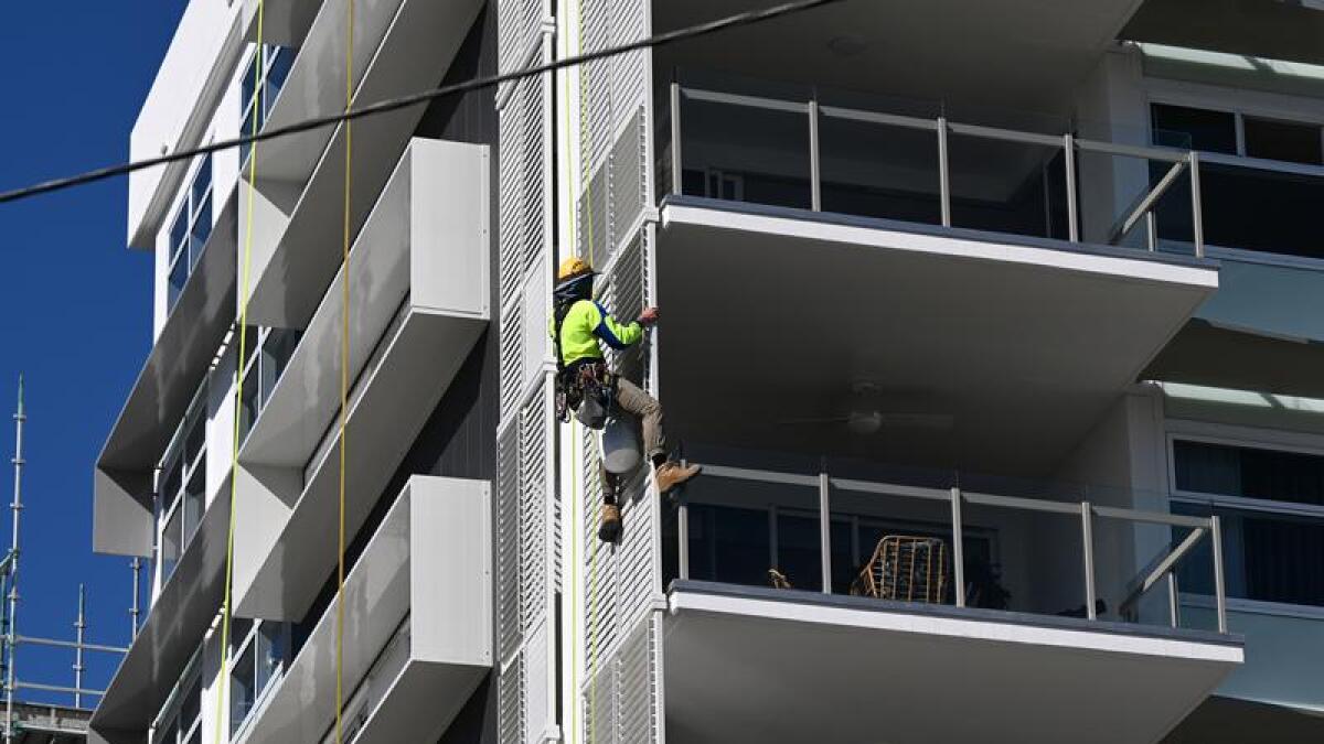 construction worker on the side of a new apartment building 