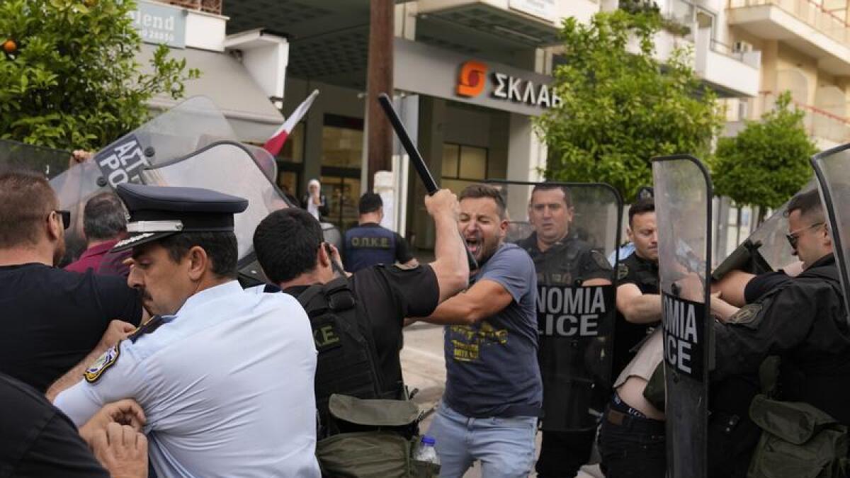 Police clash with protesters outside a court house in Kalamata