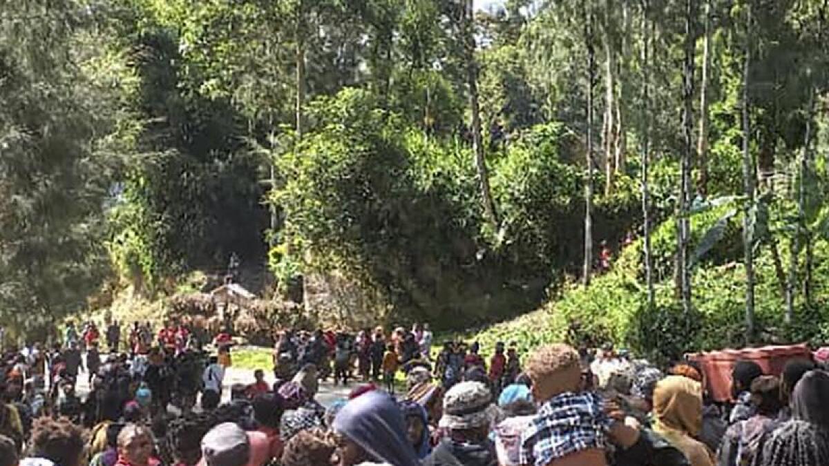 Villages hold a funeral for a landslide victim.