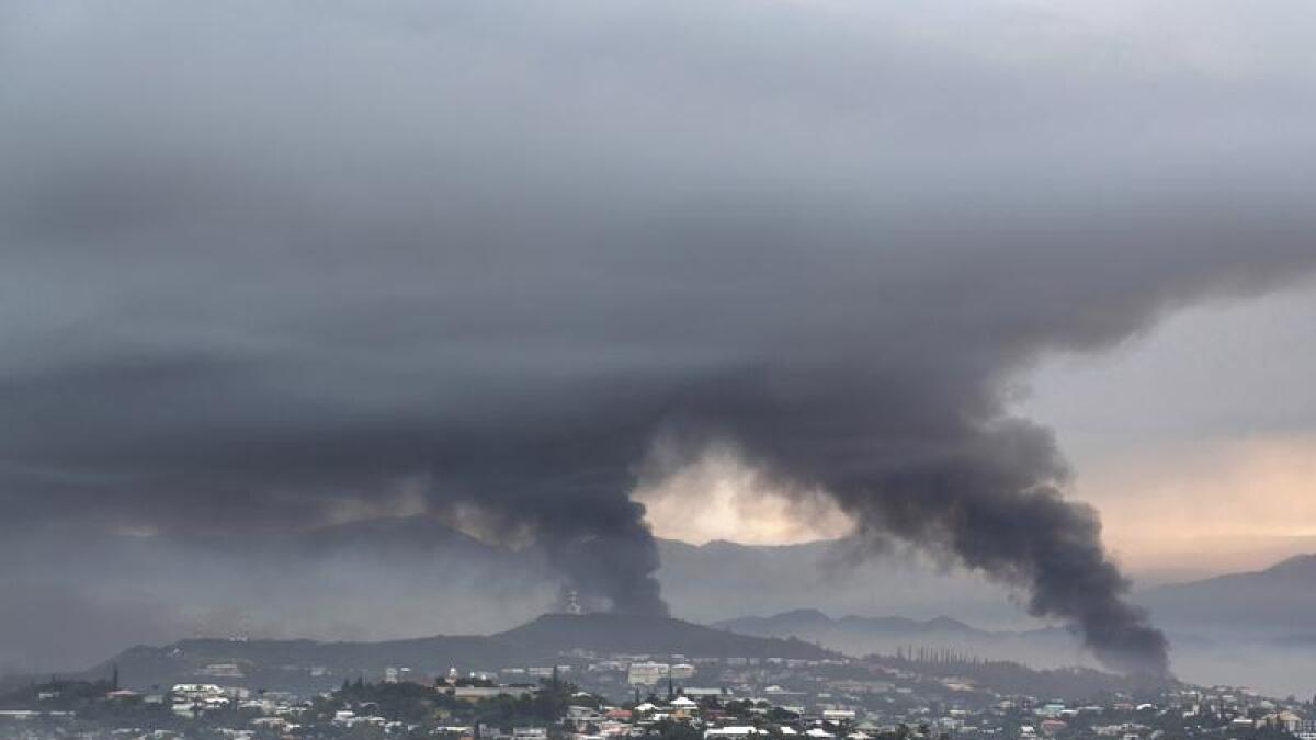 Smoke rises during protests in Noumea.