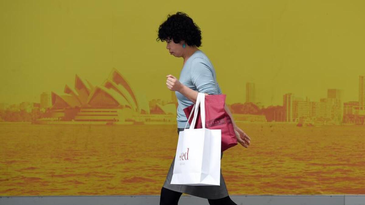 A woman carries a shopping bag.