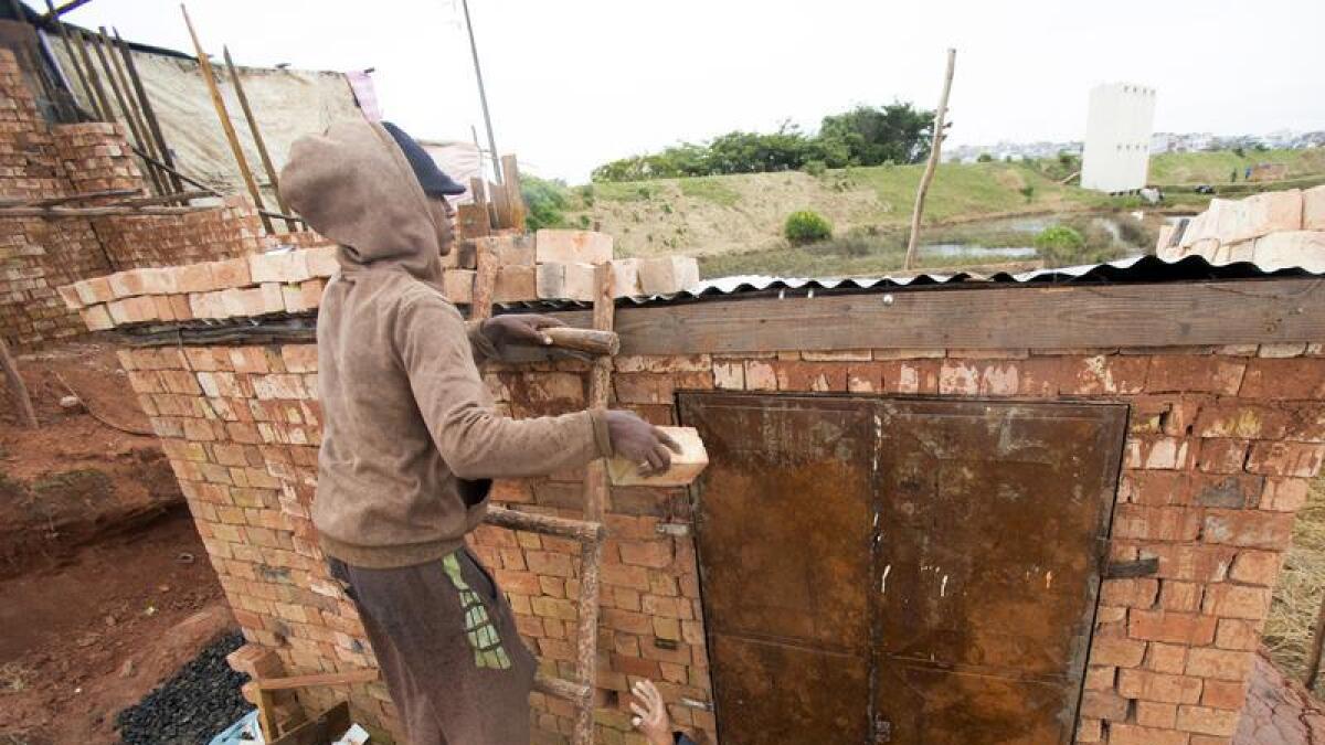 Man weighs down the roof of his home with bricks in Antananarivo