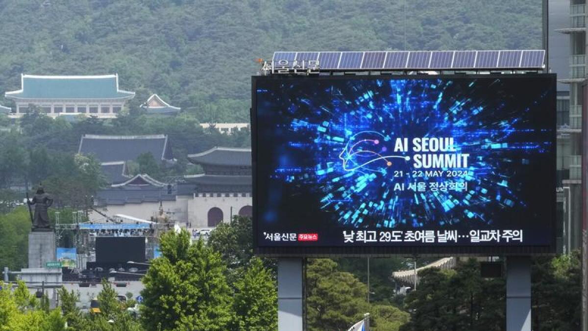 A screen shows an announcement of the AI Seoul Summit in South Korea
