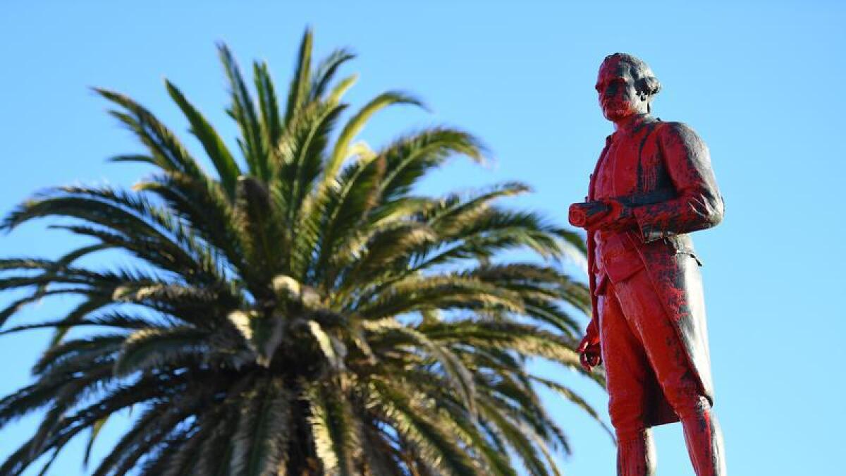 Red paint is seen covering a vandalised statue of Captain James Cook