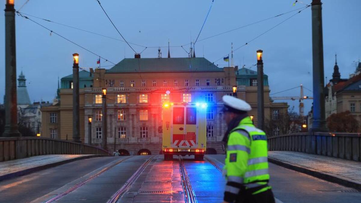 A police officer and an ambulance at the scene of a shooting in Prague