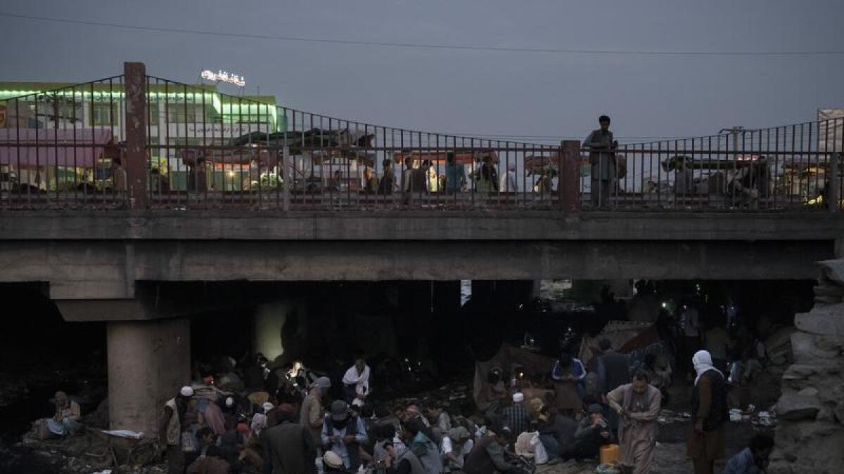 Afghans gather under a bridge to consume drugs