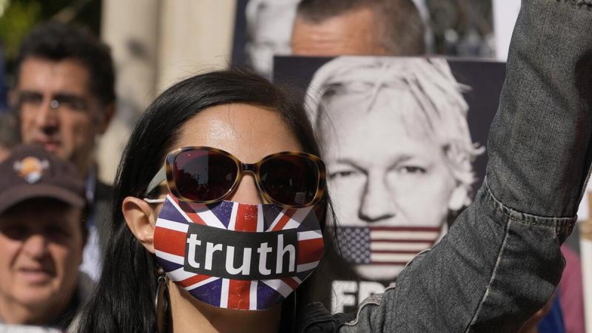 A supporter of Julian Assange protests outside London's High Court