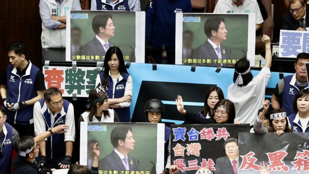 Taiwanese MPs display placards of President Lai Ching-te in parliament