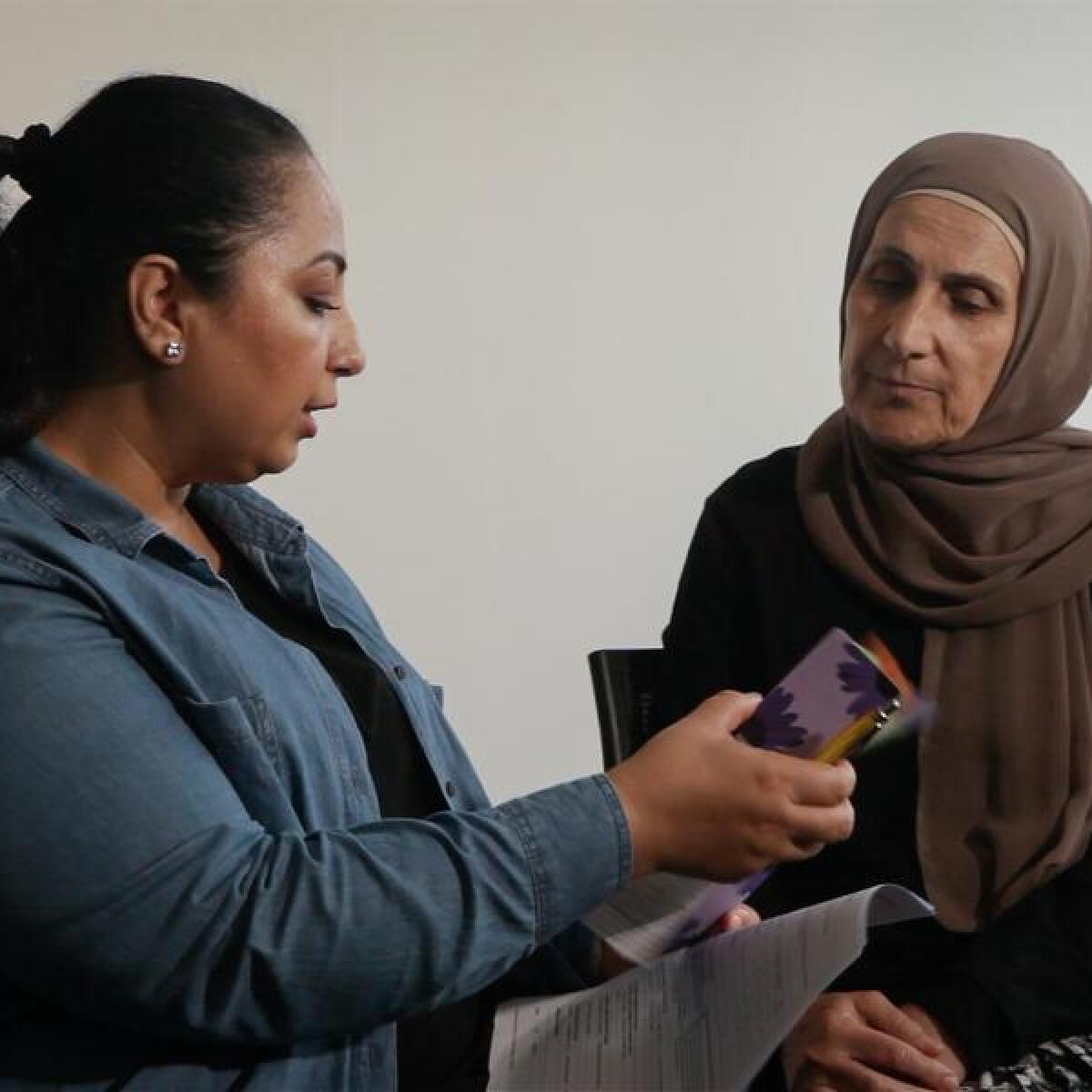 A caseworker with a woman who took part in a domestic violence survey