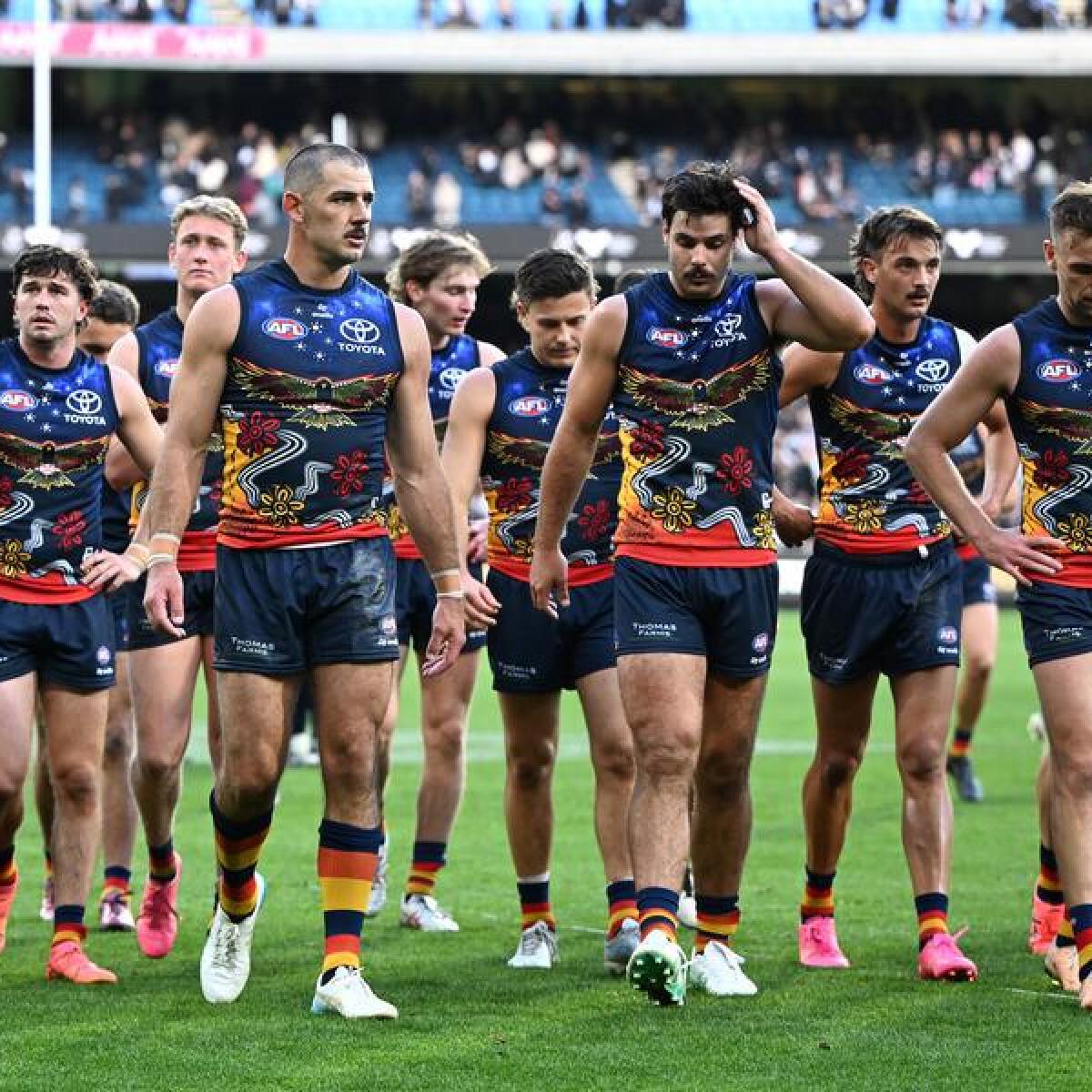 Adelaide Crows players leave the MCG.