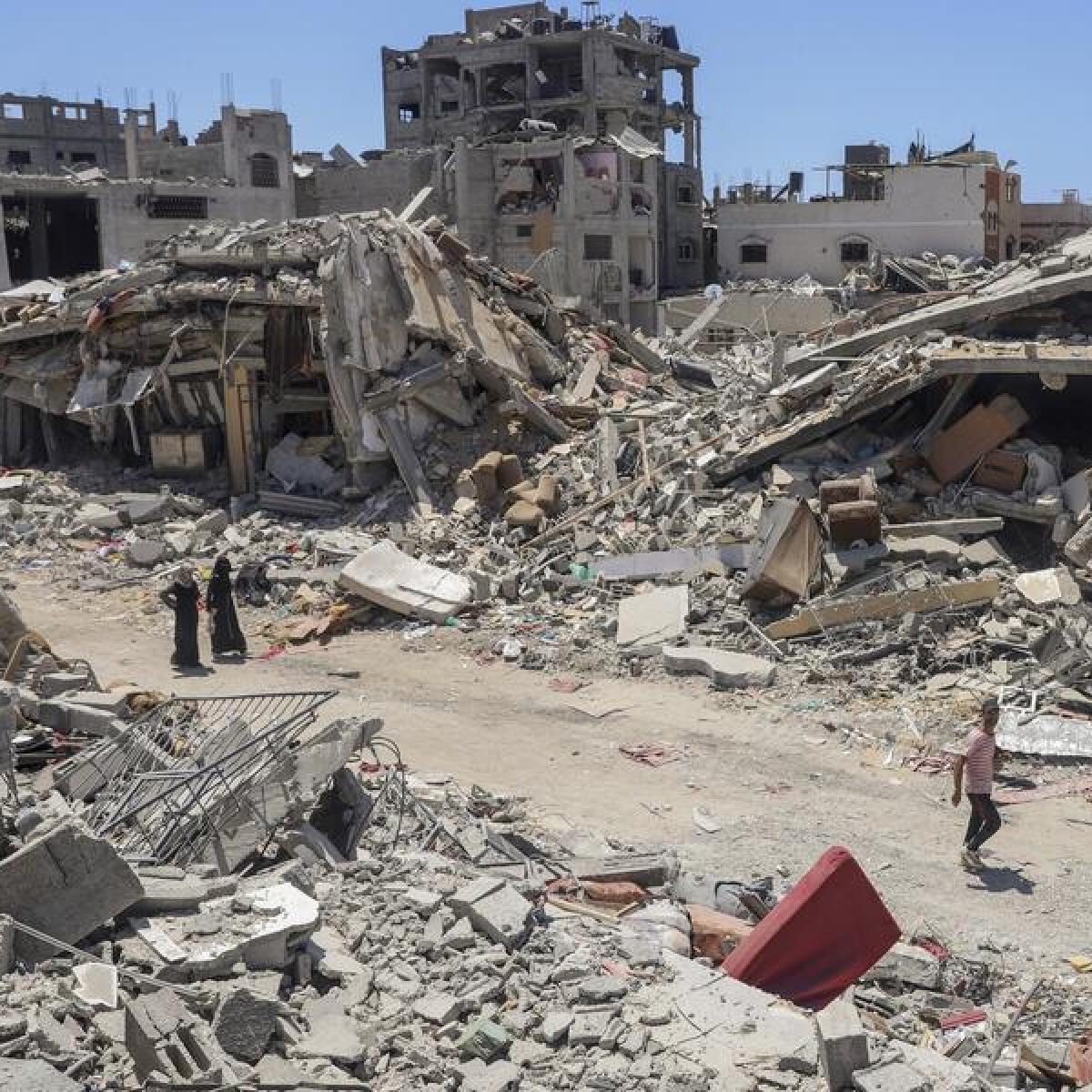 Palestinians walk through the destruction in Gaza Strip's north