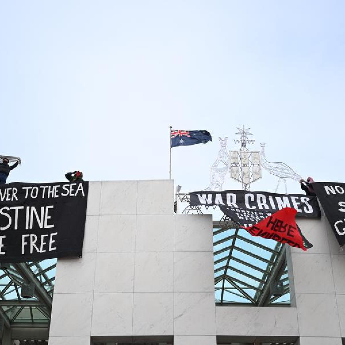 Pro-Palestine protesters have hung banners from Parliament House.