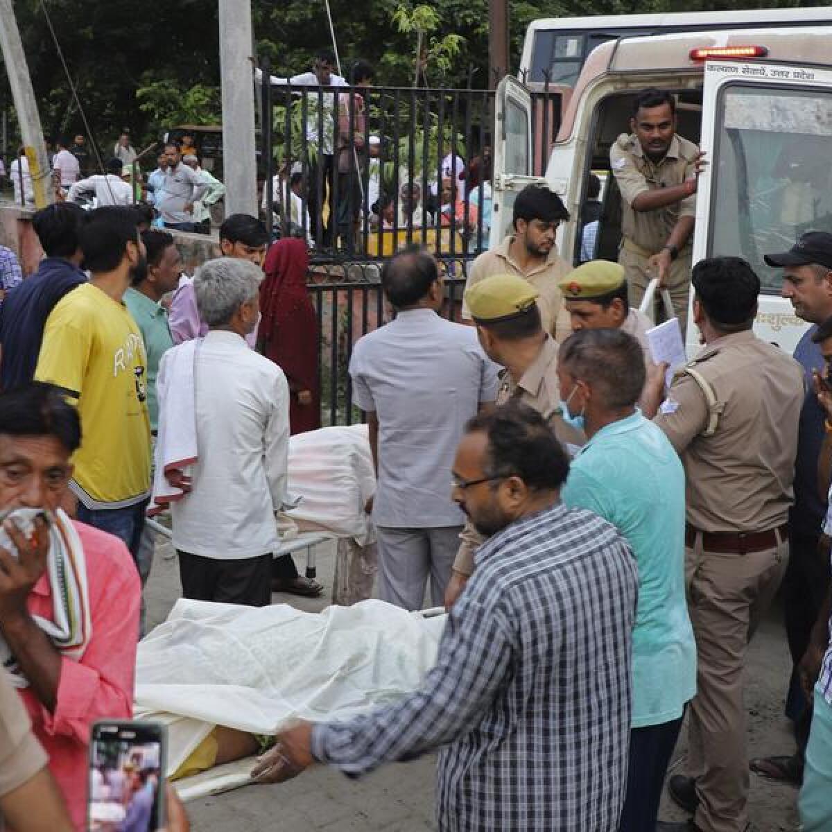 Relatives and volunteers carry bodies at the Sikandrarao hospital