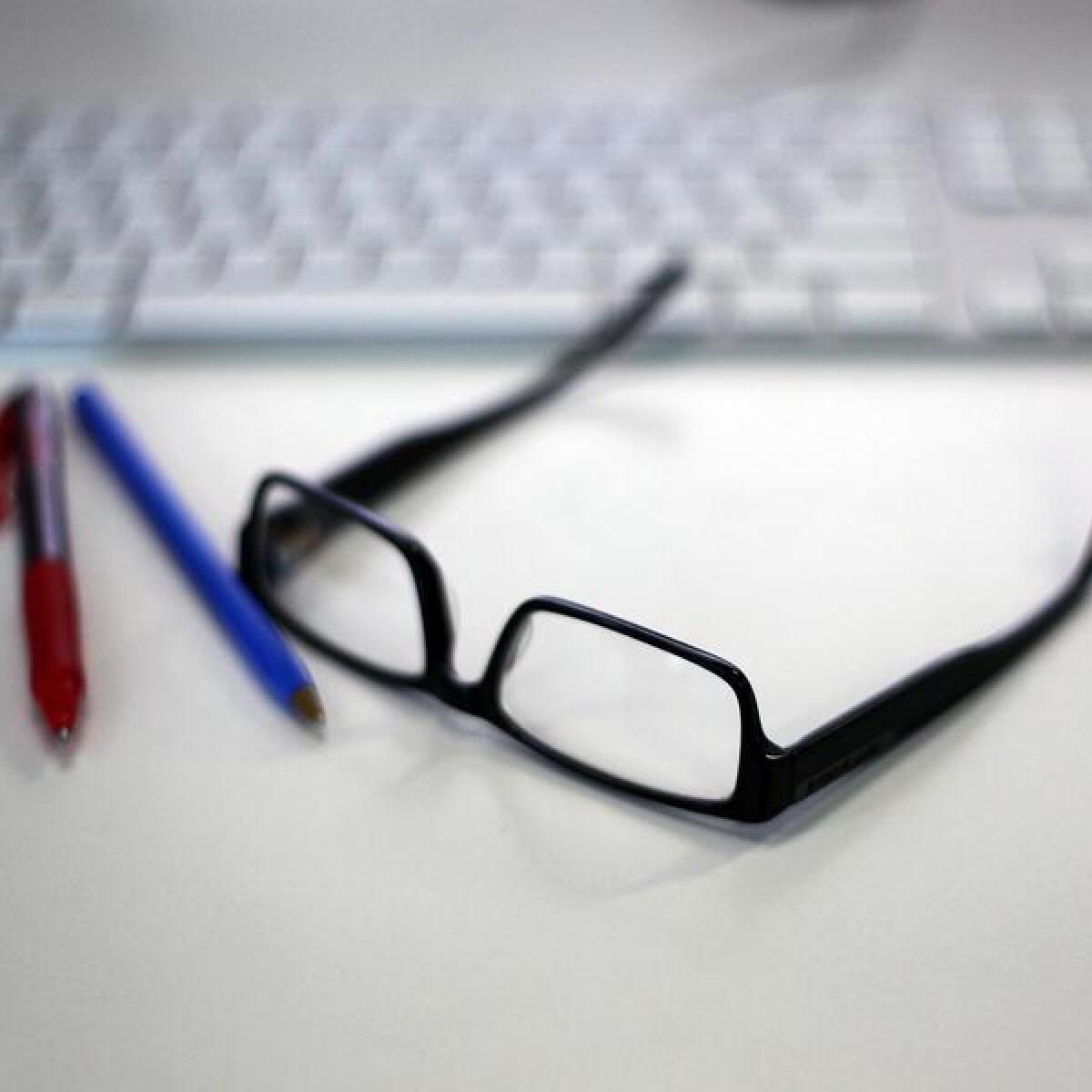 Reading glasses, pens and a keyboard