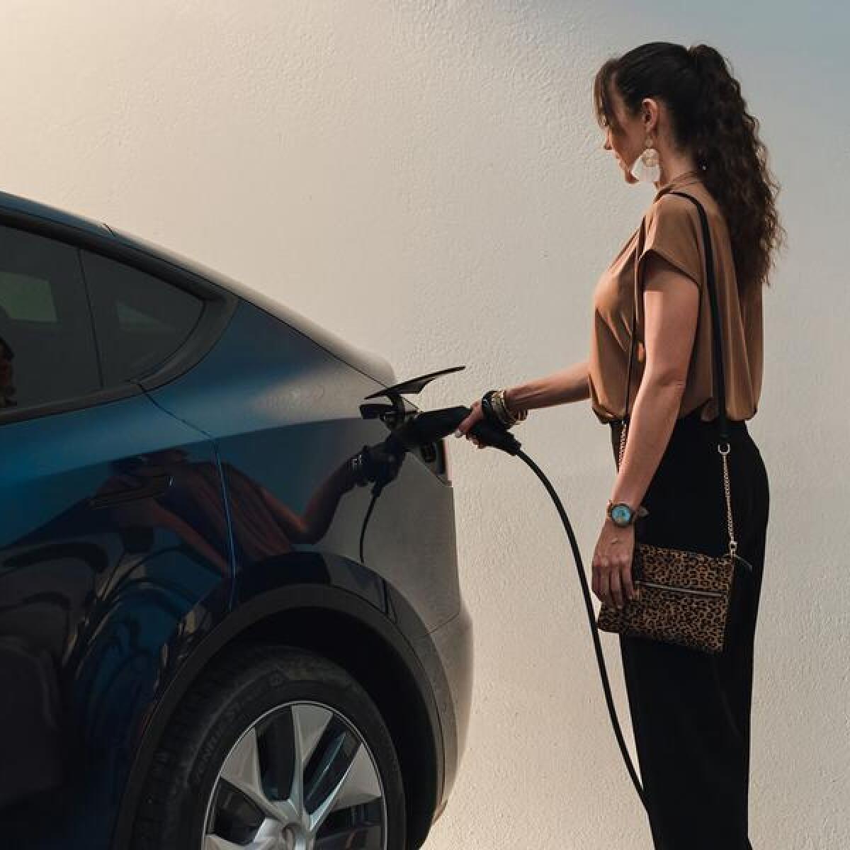 A woman charging an electric vehicle