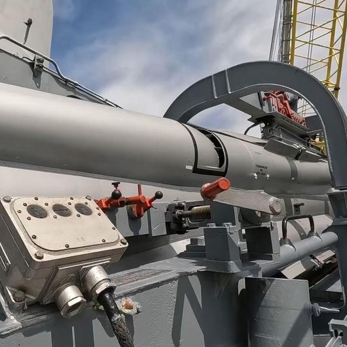 Russian military personnel load a cruise missile on board a warship