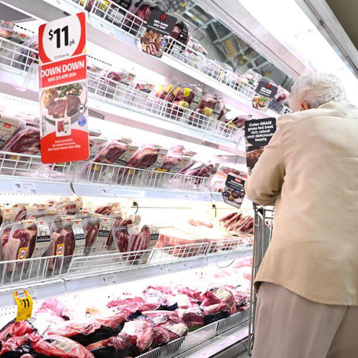 An elderly woman shopping in a supermarket.