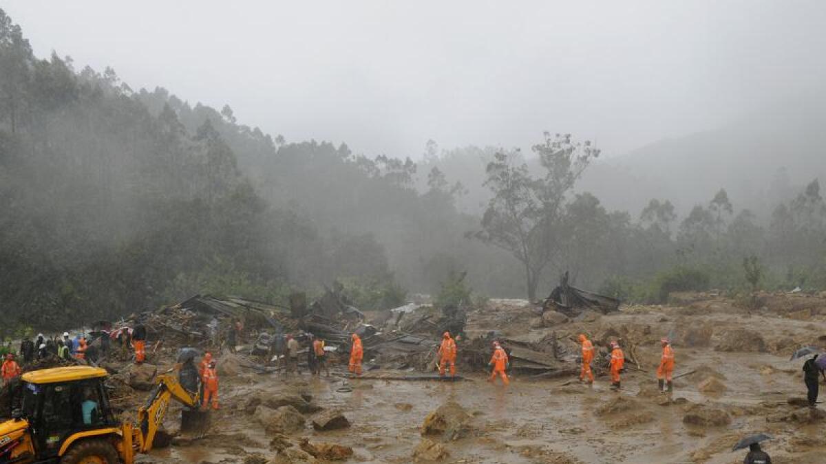 Rescuers at the site of a mudslide triggered by heavy rain in India.