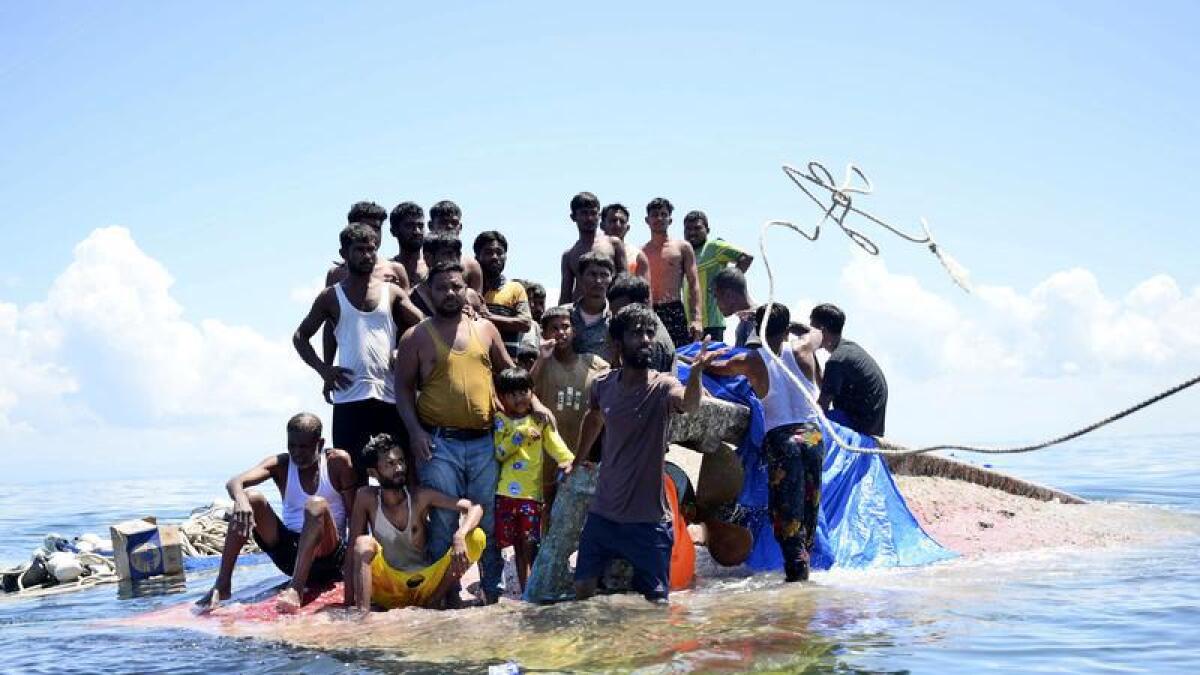 Rohingya refugees on their capsized boat in the waters off West Aceh