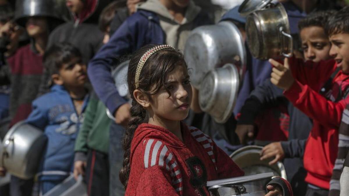 Palestinian children queue up for food