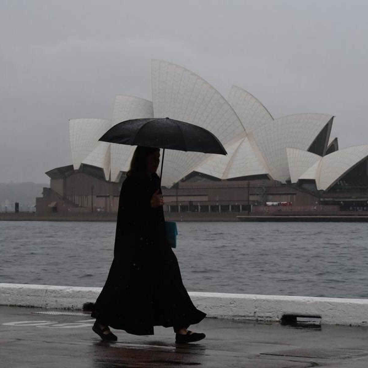 A person walks in the rain in Sydney