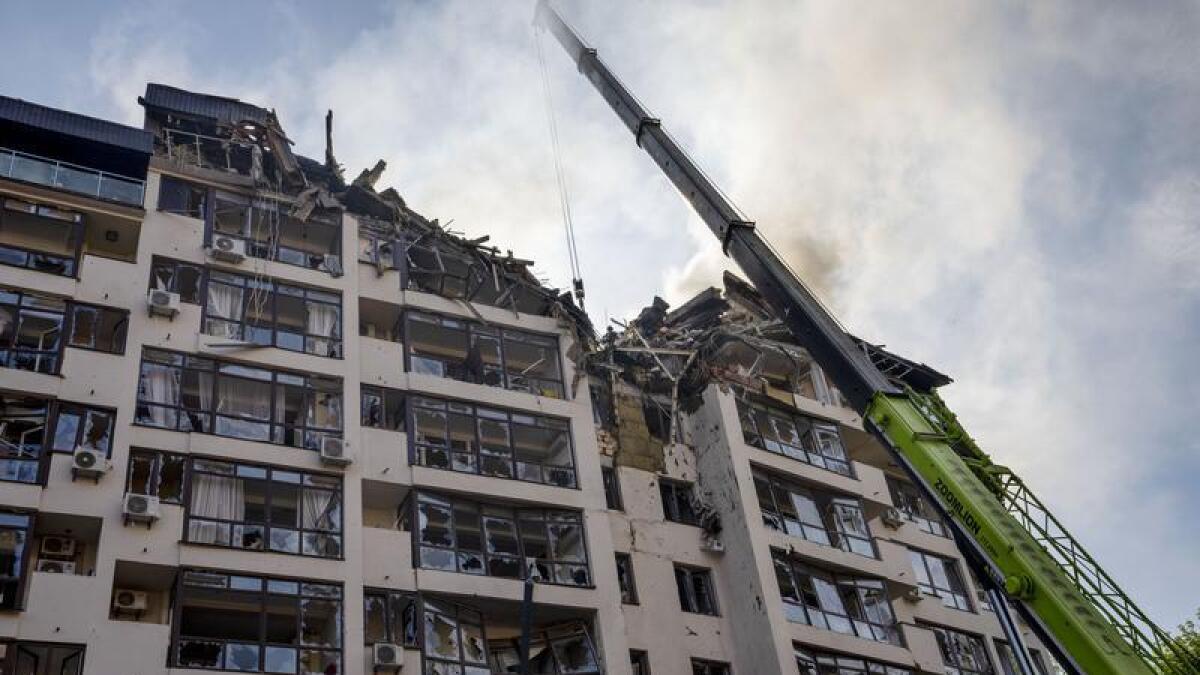 Firefighters at a residential building following explosions, in Kyiv.