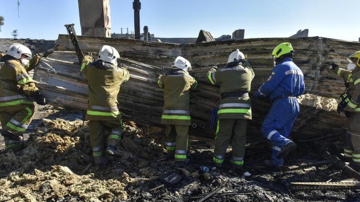 Firefighters at the destroyed shopping mall in Kremenchuk