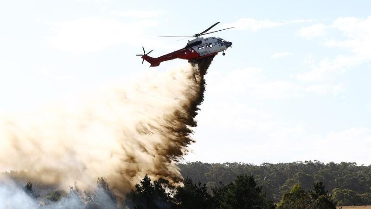 A helicopter fights a spot fire outside Beaufort, Victoria.