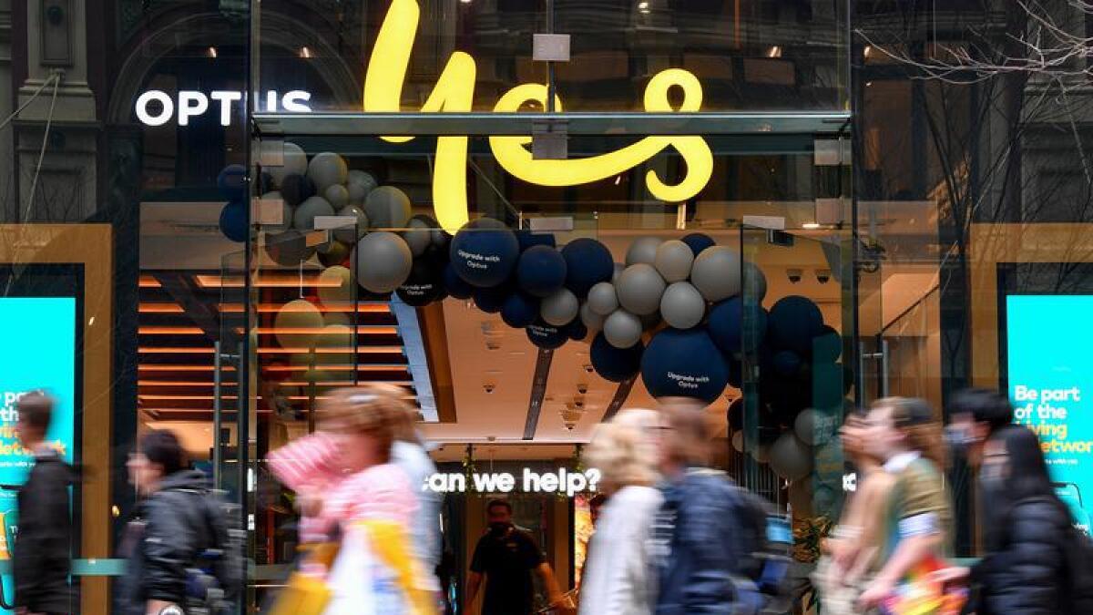 Shoppers walk past an Optus store in Sydney.