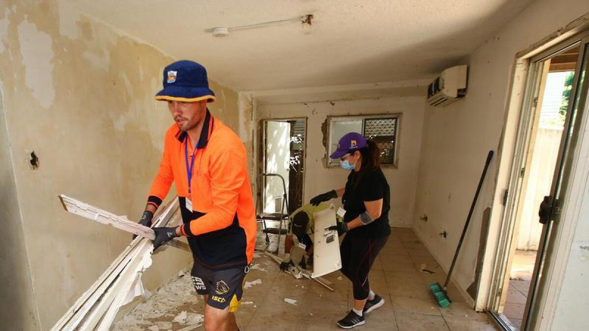 Members of the 'mud army' help clear debris from a home in Brisbane.