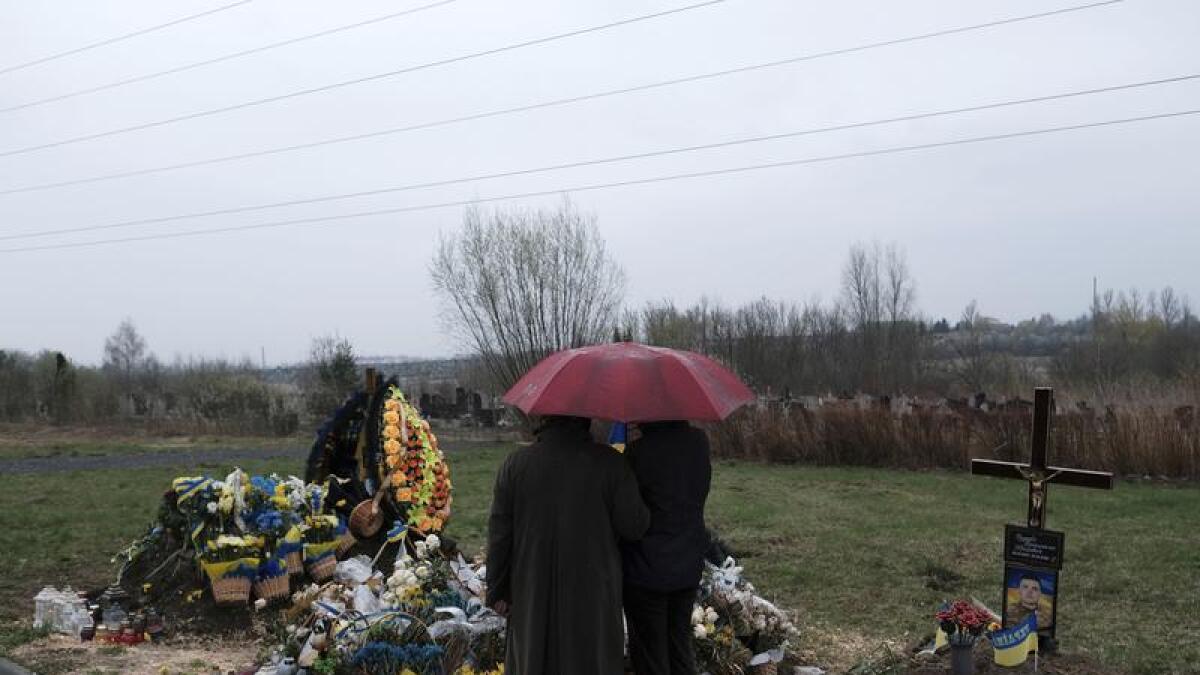 Women mourn a soldier killed in Russia's invasion of Ukraine.