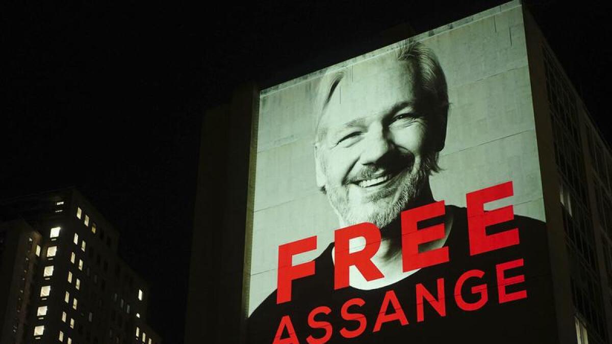 An image of Julian Assange is projected onto a building in London.