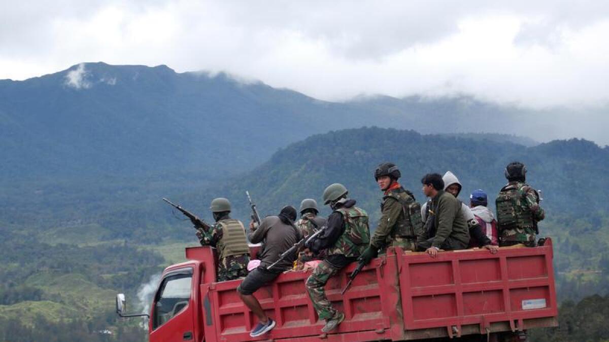 Indonesian police and military officers conduct a patrol.