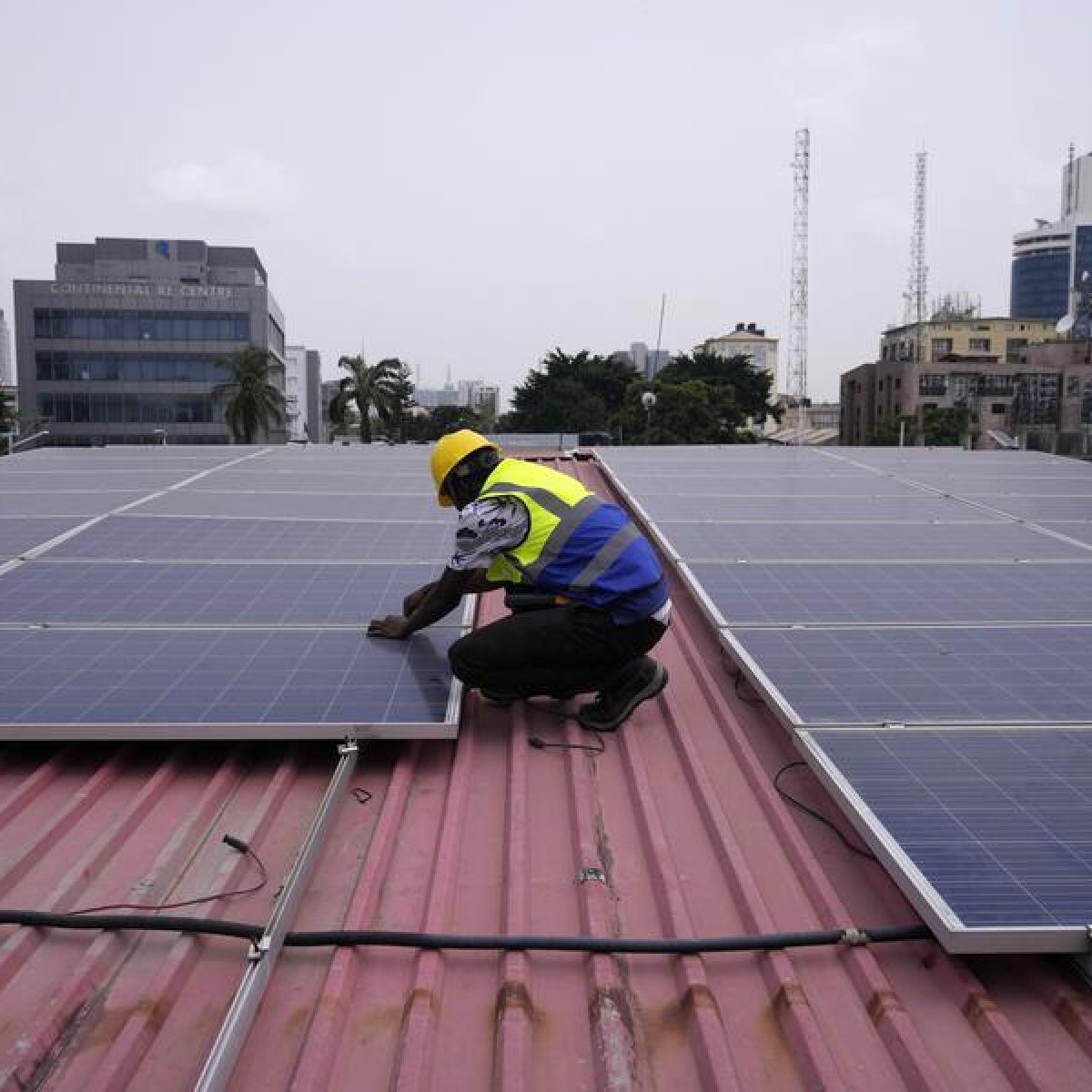 Worker installs solar panels on a roof