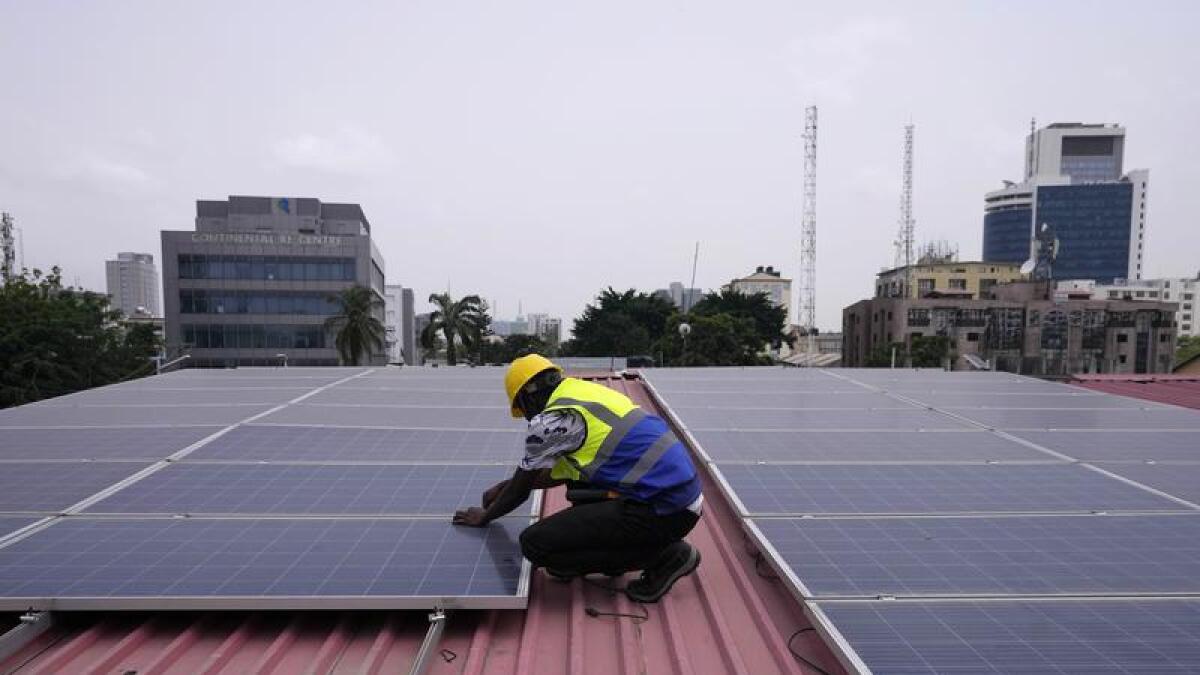 Worker installs solar panels on a roof