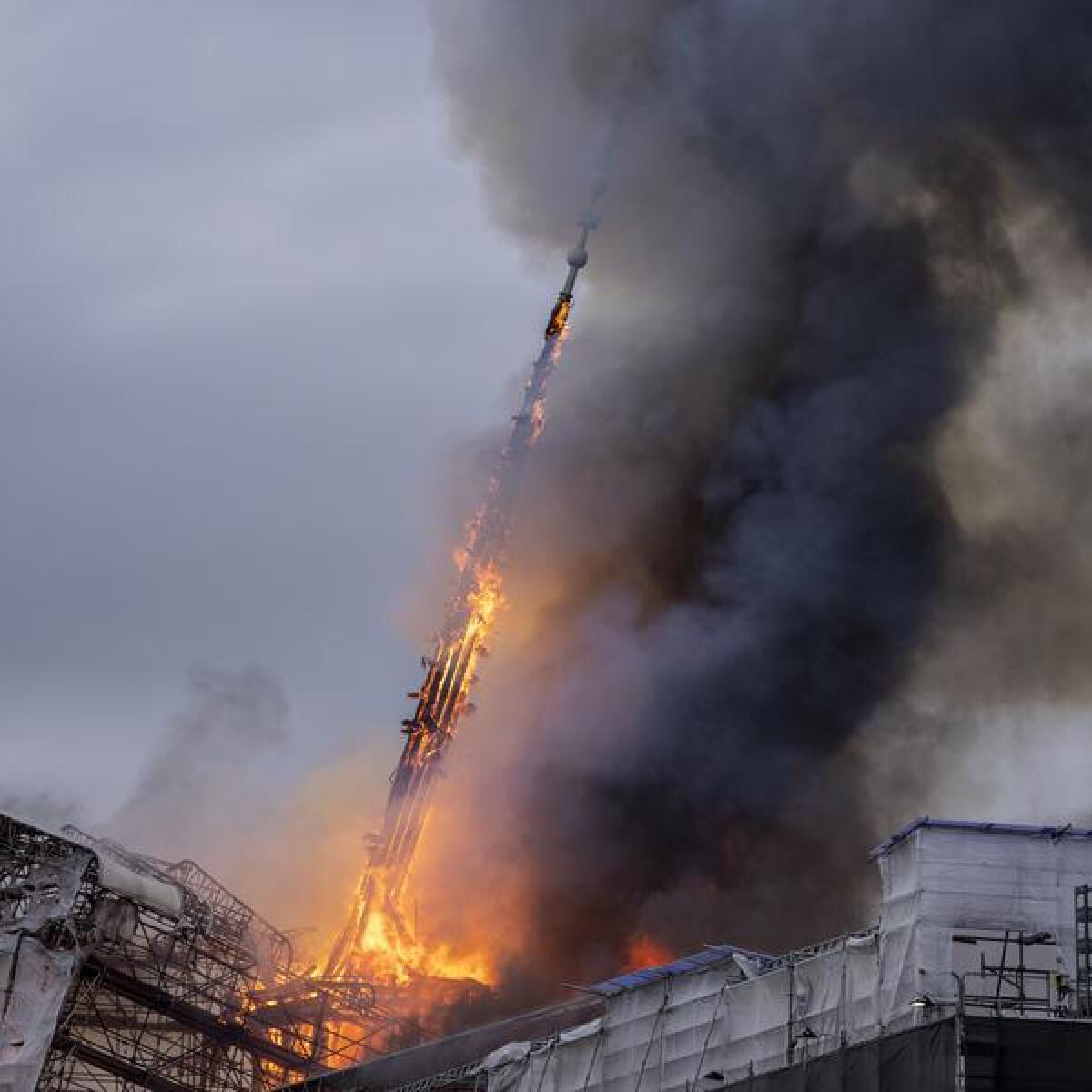 The spire collapses during a fire at the Old Stock Exchange 
