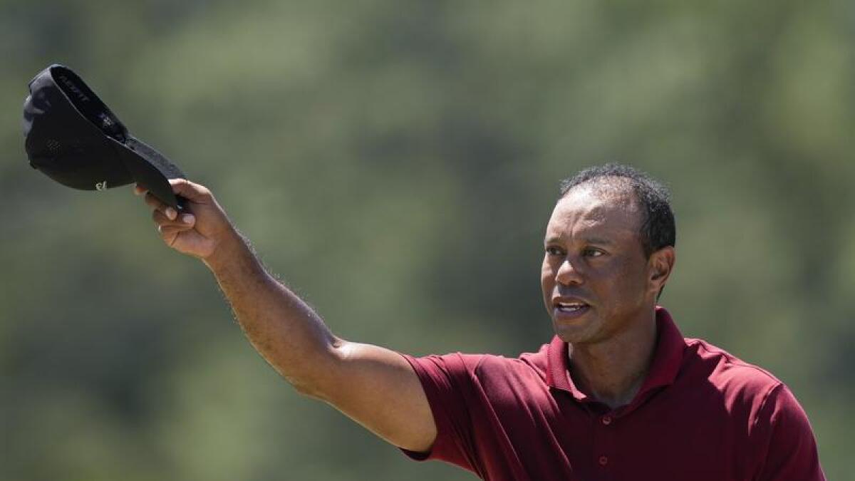 Tiger Woods doffs his cap. 