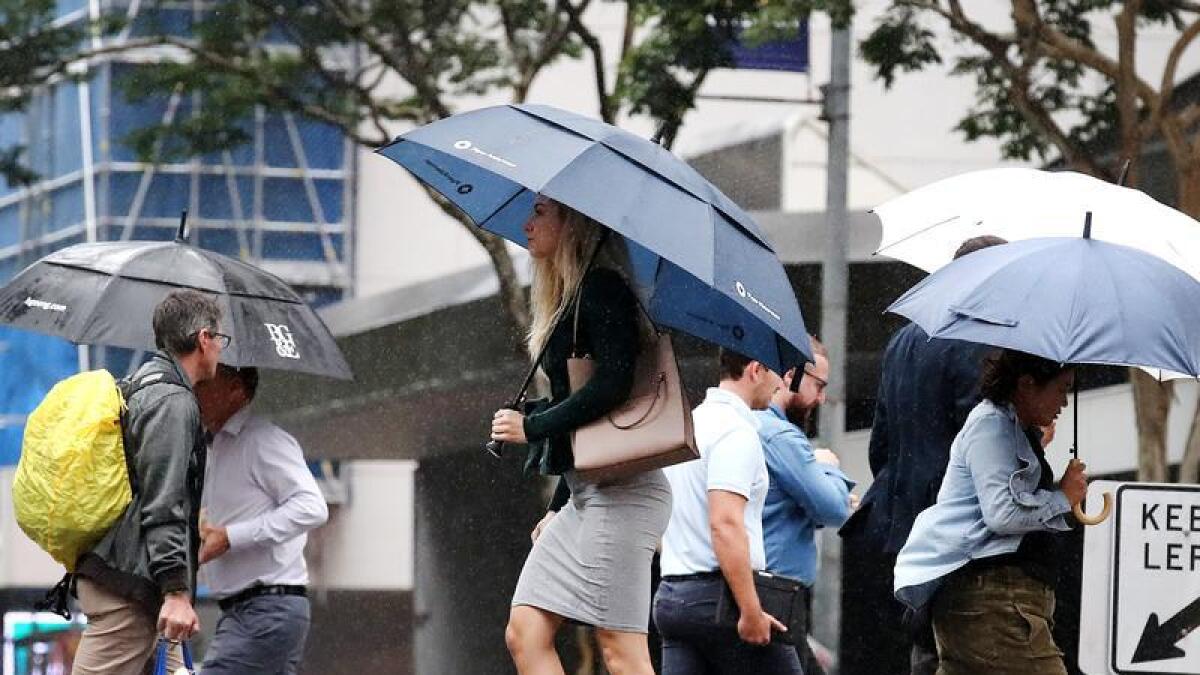 Pedestrians with umbrellas.
