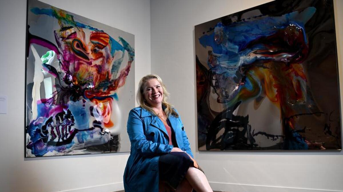 Katrina Cashman in front of two paintings.