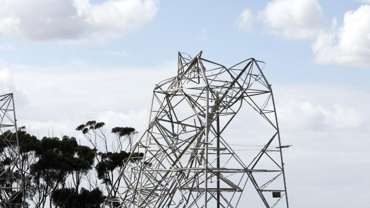 Workers inspect damaged electricity towers at Anakie in Melbourne