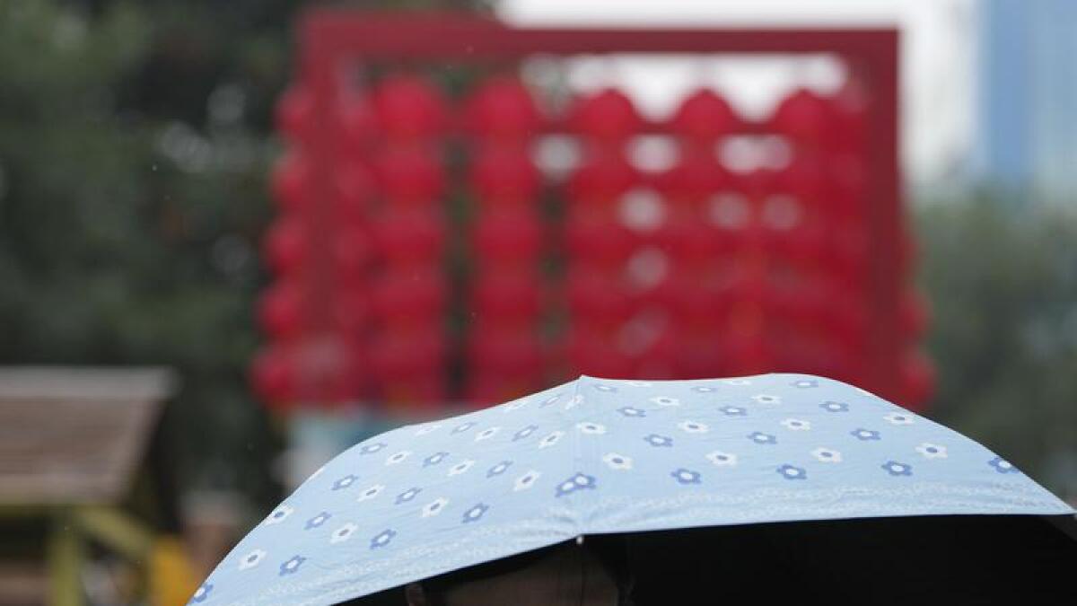 A woman uses an umbrella during a rainy day in Beijing