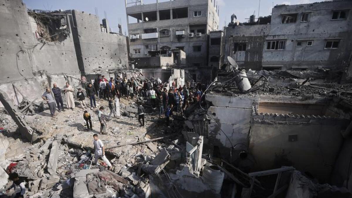 Palestinians look at destruction after the Israeli bombing