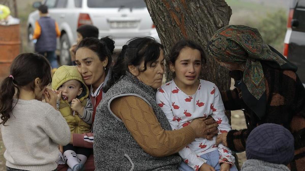Ethnic Armenians from Nagorno-Karabakh comfort a young girl