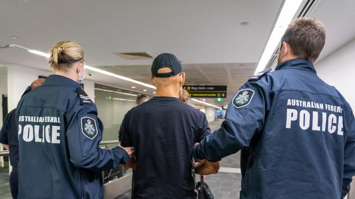 A Chinese-British national escorted by Australian Federal Police
