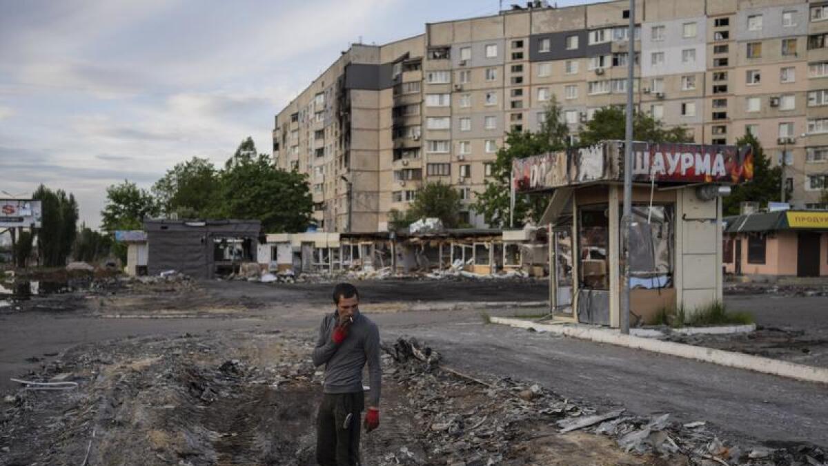 A man searches for metal scraps in a shelled neighbourhood in Kharkiv