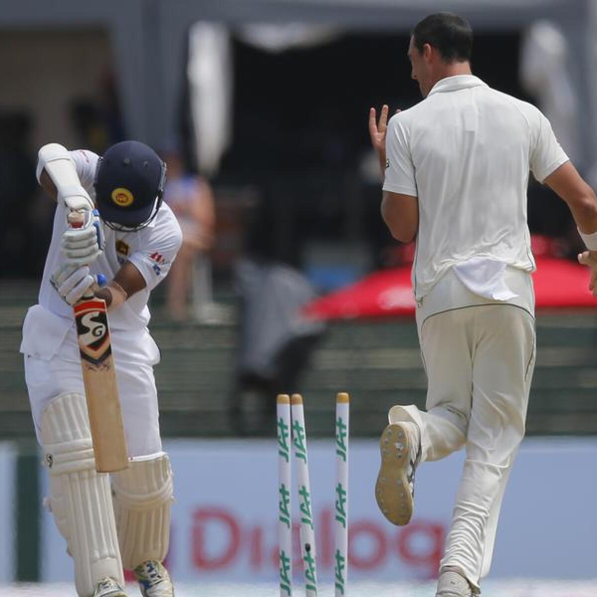 Mitchell Starc celebrates the wicket of Dimuth Karunaratne.